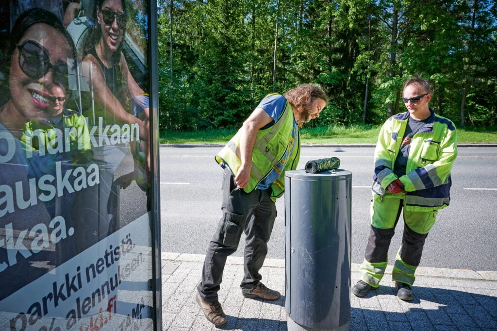 Työnjohtaja Jussi Nyman ja puistotyöntekijä Jaana Holm tarkastelevat bussipysäkin roska-astian kuntoa Espoonlahdessa Espoossa.