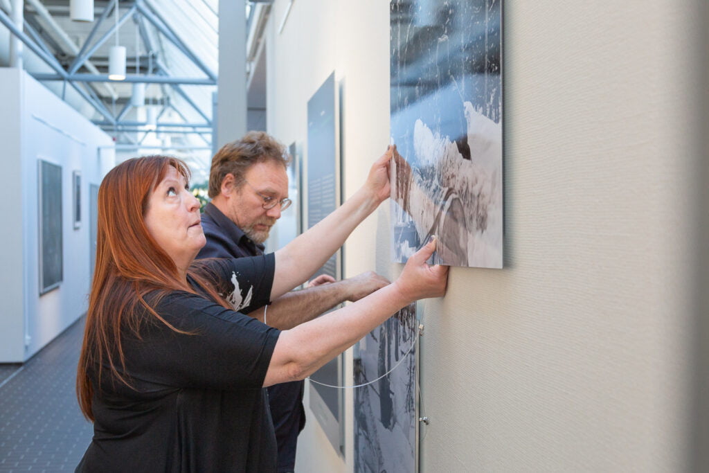 Marjo Nurmi ja Hannu Laakso mittailevat teoksia oikeille paikoilleen.