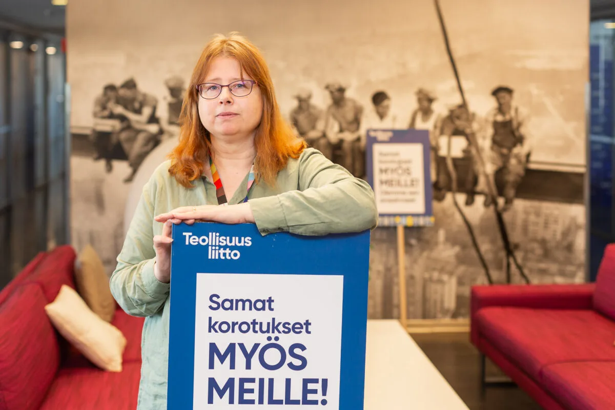 Teollisuusliiton puutuotesektorin johtaja Katariina Stoor. mielenosoituskyltin kanssa.