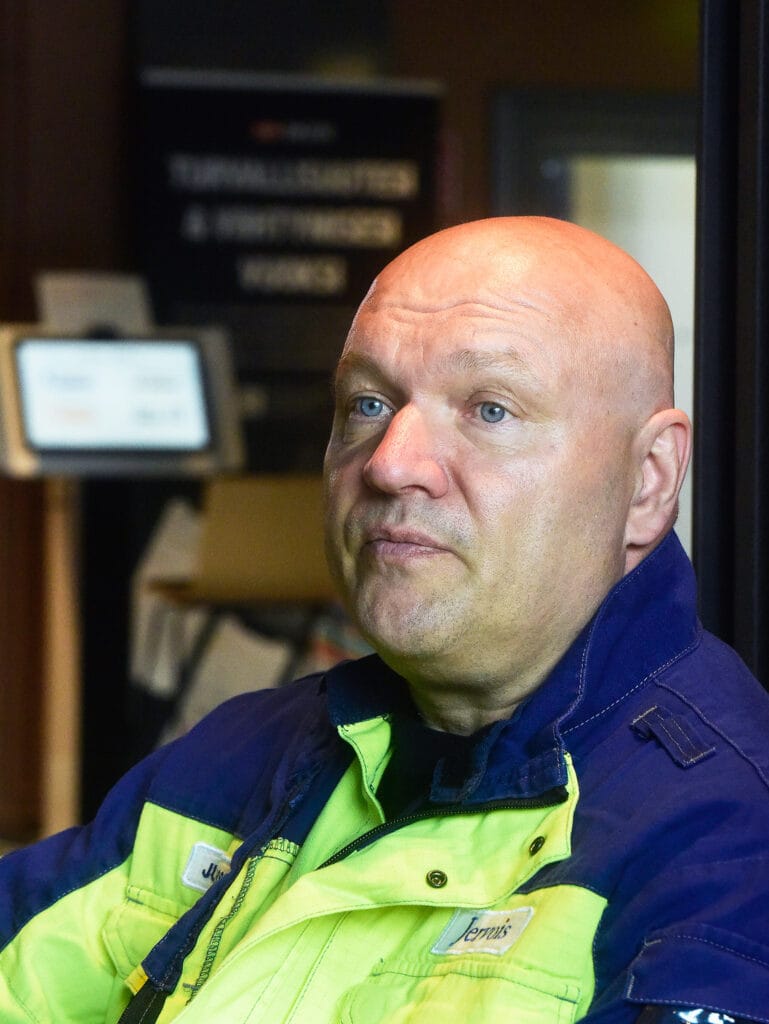 Mies työpaikalla työvaatteet päällänsä.