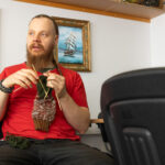 Henkilö neuloo värikästä villasukkaa sisätiloissa.