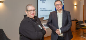 Nainen ja mies seisovat pöydän luona.