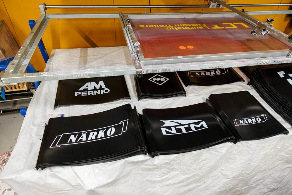 Svarta stänkskärmar i sex högar. Skärmarna pryds av företagslogon som Närko och NTM. 