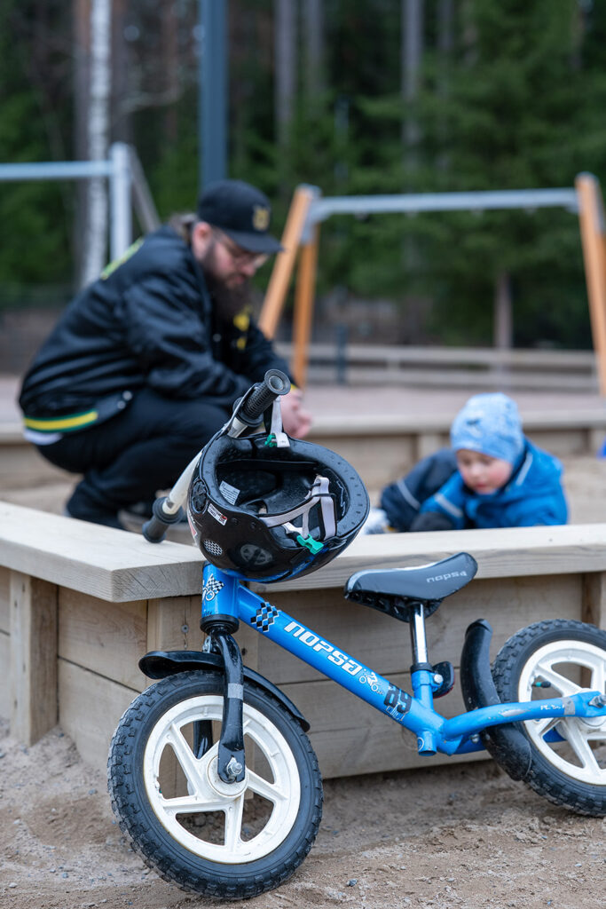 Mies ja lapsi hiekkalaatikolla