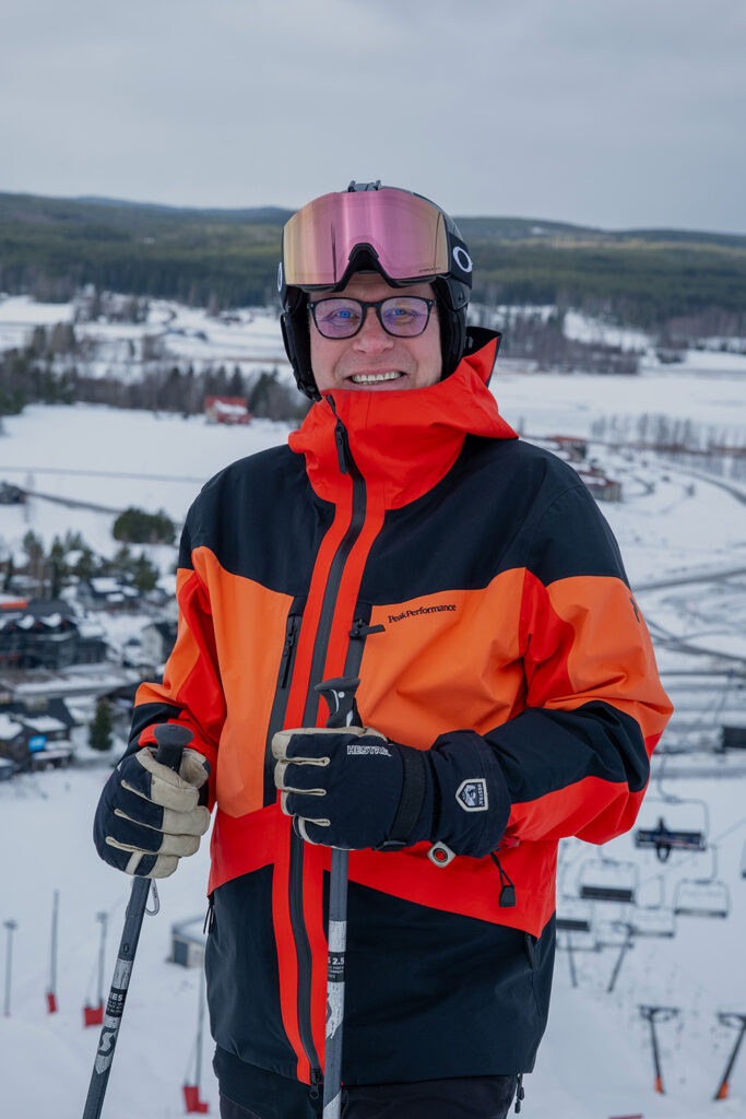 Mies katsoo kameraan lasketteluvarusteissa