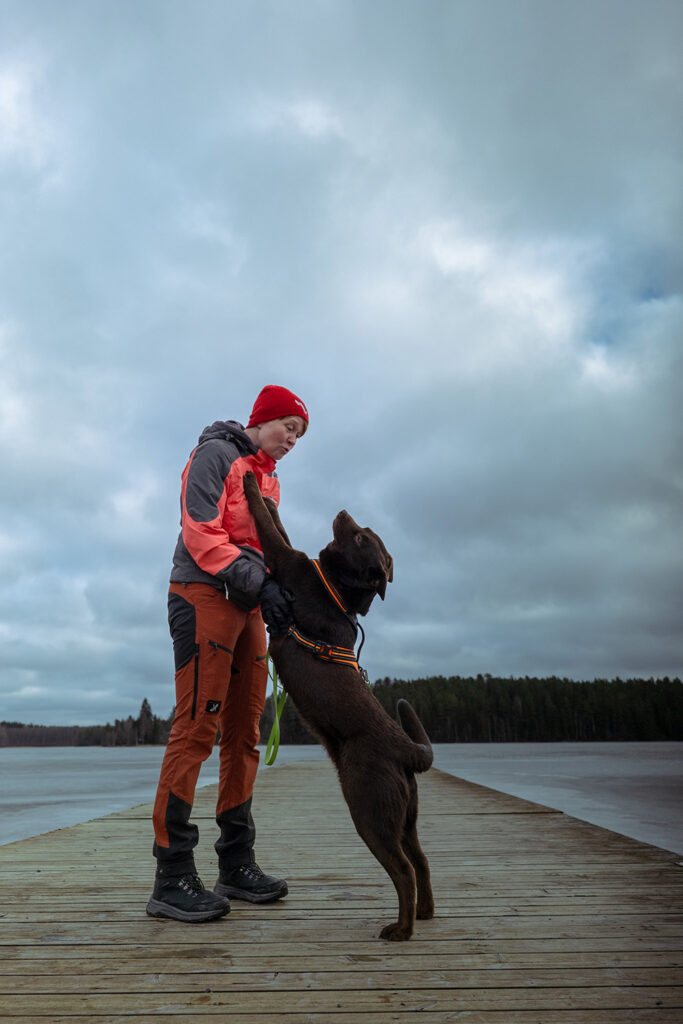 Nainen ja koira ulkona laiturilla