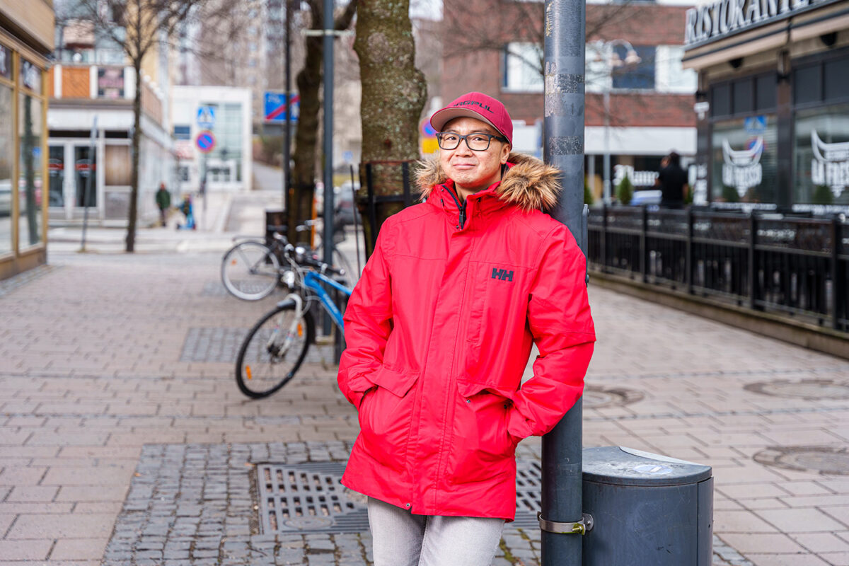 Mies nojaa lyhtypylvääseen ulkona