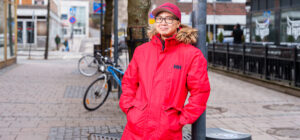 Mies nojaa lyhtypylvääseen ulkona